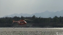四川都江堰两男子下河游玩被困河心岛 出动直升机救援